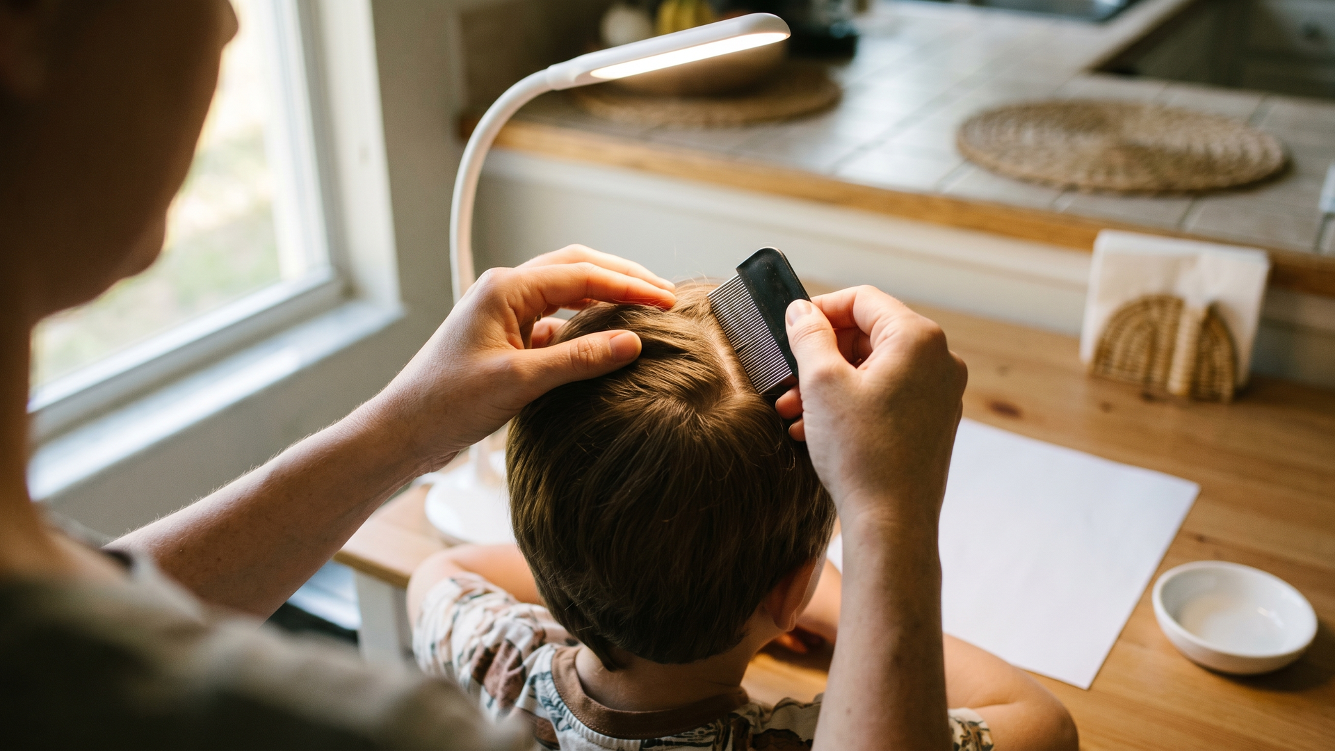 Parent checking hair for lice nits versus dandruff flakes