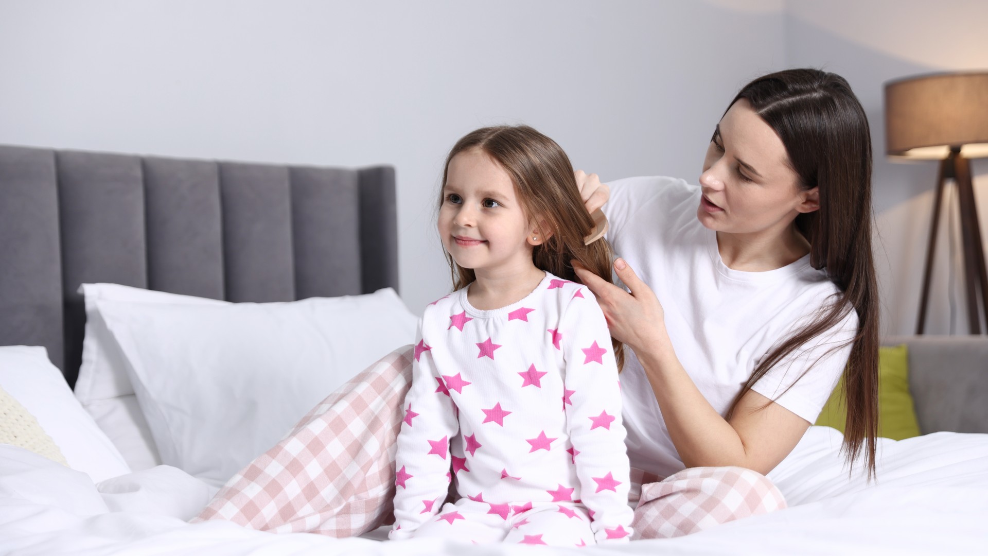 Parent calmly checking a child at bedtime during a stressful lice situation