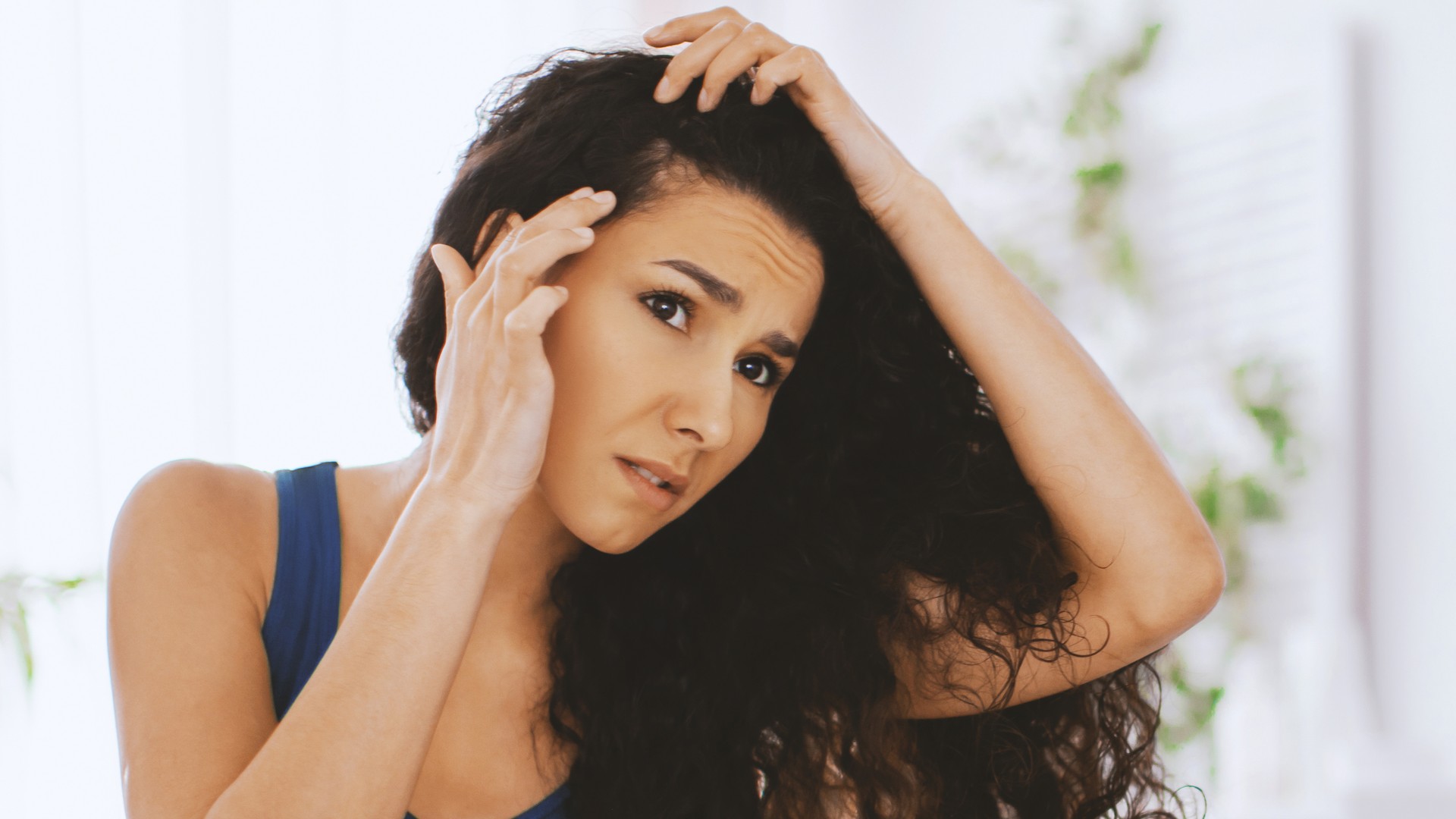 Adult checking her own scalp for signs of head lice