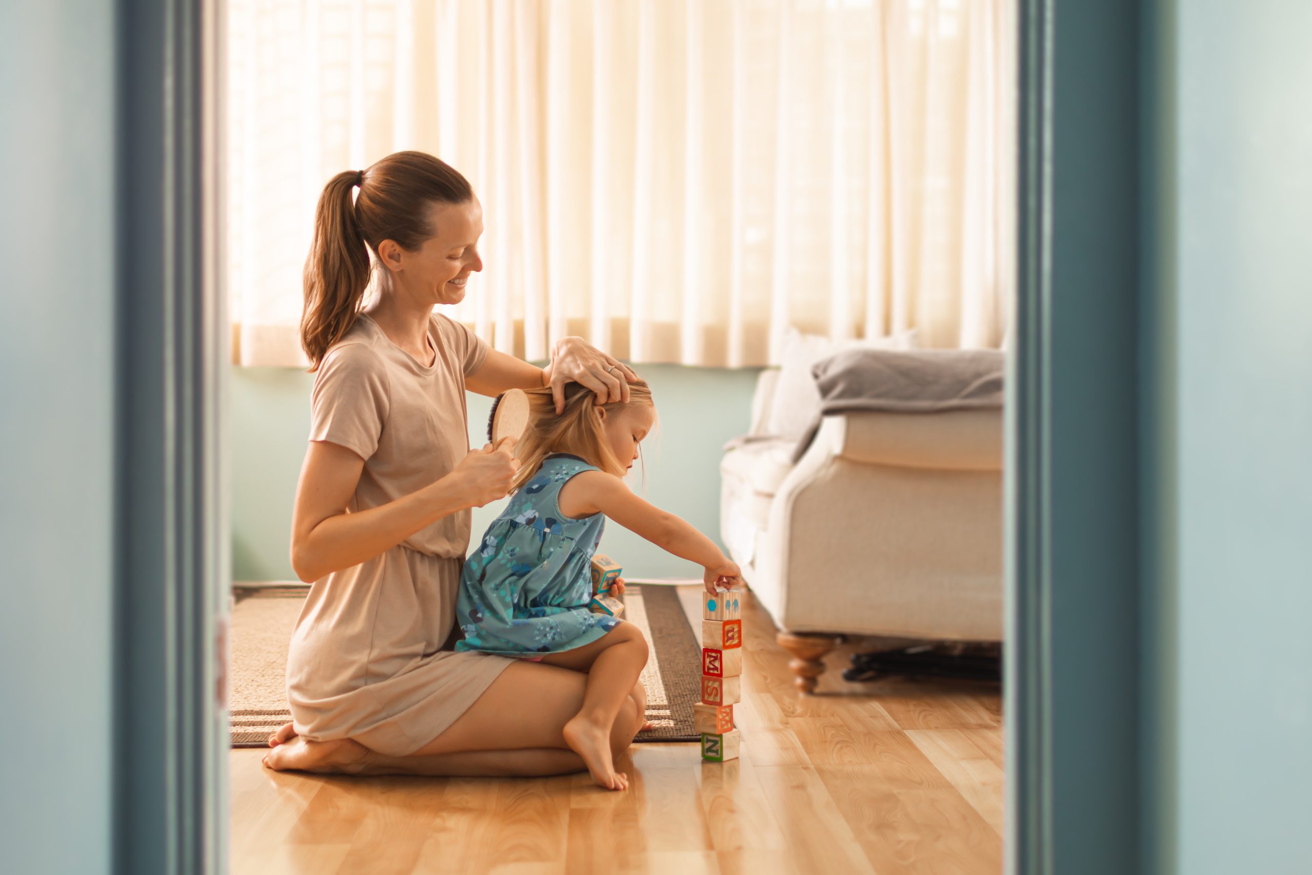 Parent gently checking a child's hair for lice risk across hair types