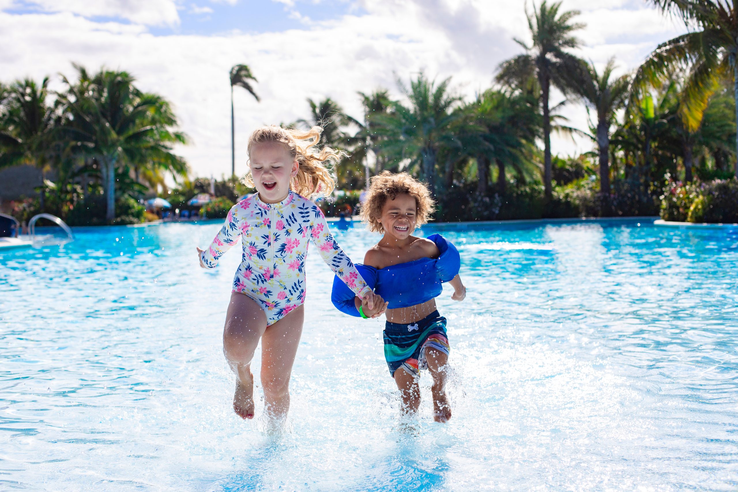 Children splashing in a pool for waterpark and pool head lice guidance