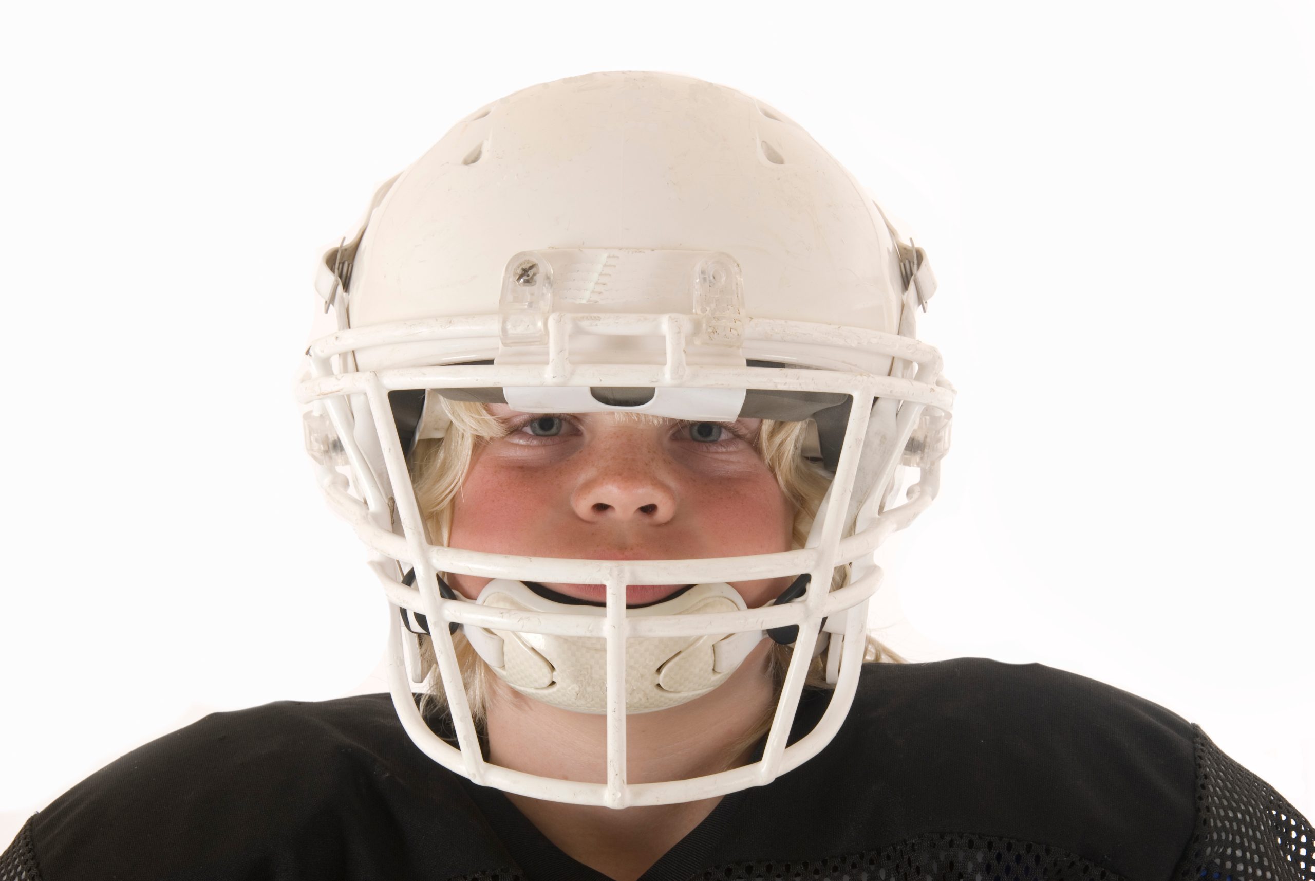 Child wearing football helmet for youth sports lice prevention