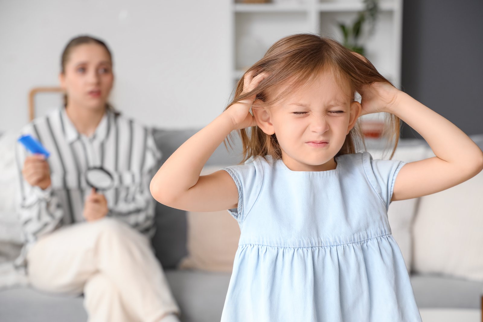 Young child at home scratching an itchy scalp from head lice
